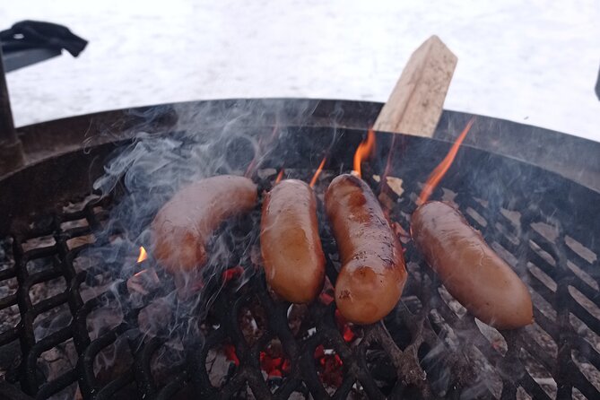 Ice fishing experience with Backpacker Helsinki Tour - The fireside finish: sausages, glögi, and piparri
