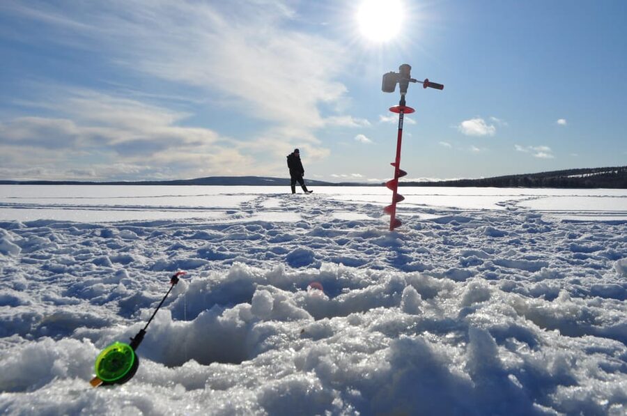 Ice fishing program in Lapland - Warm up by birch fire: salmon sandwich, berry juice, and calm